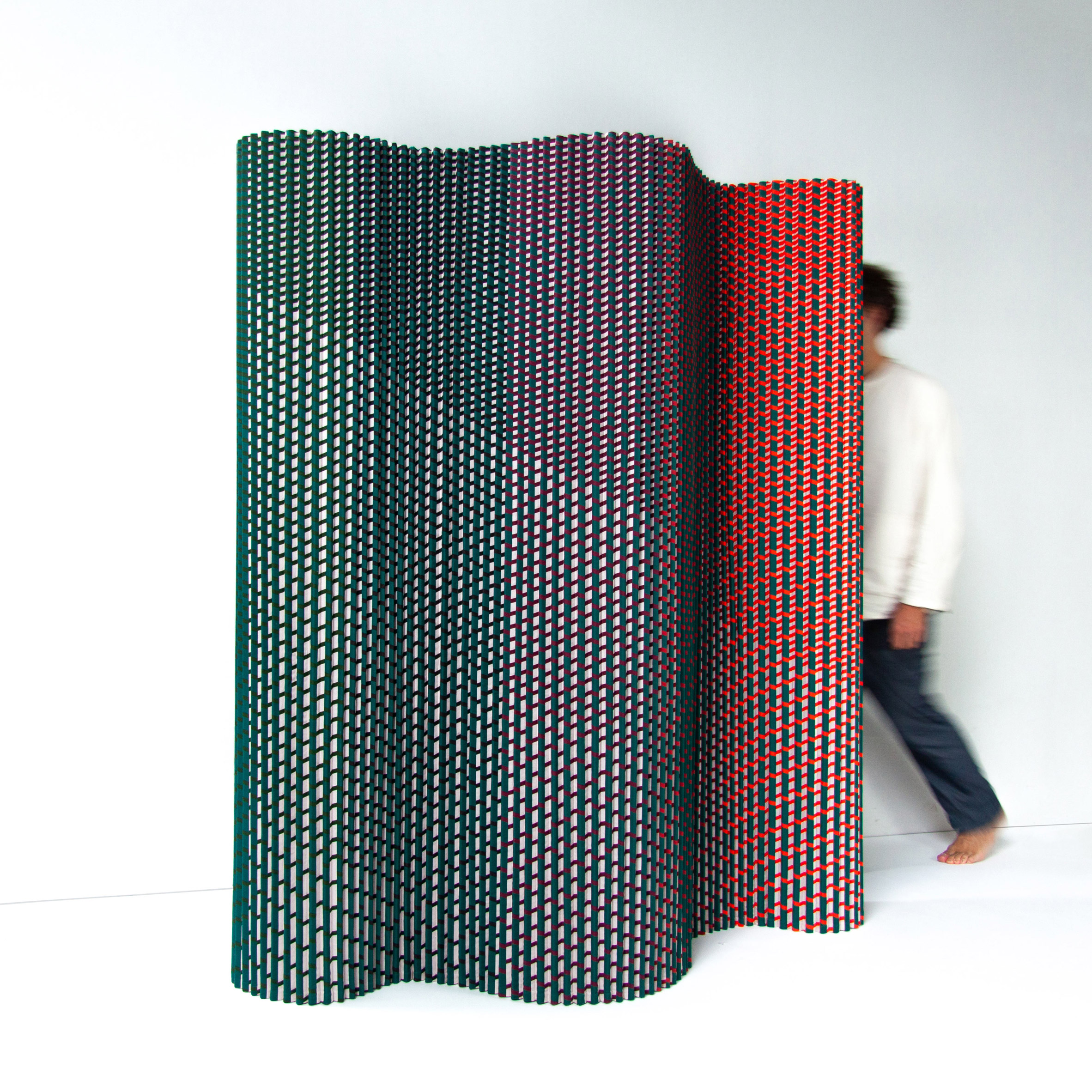Plissade, a textile-based room divider, in green, blue and red