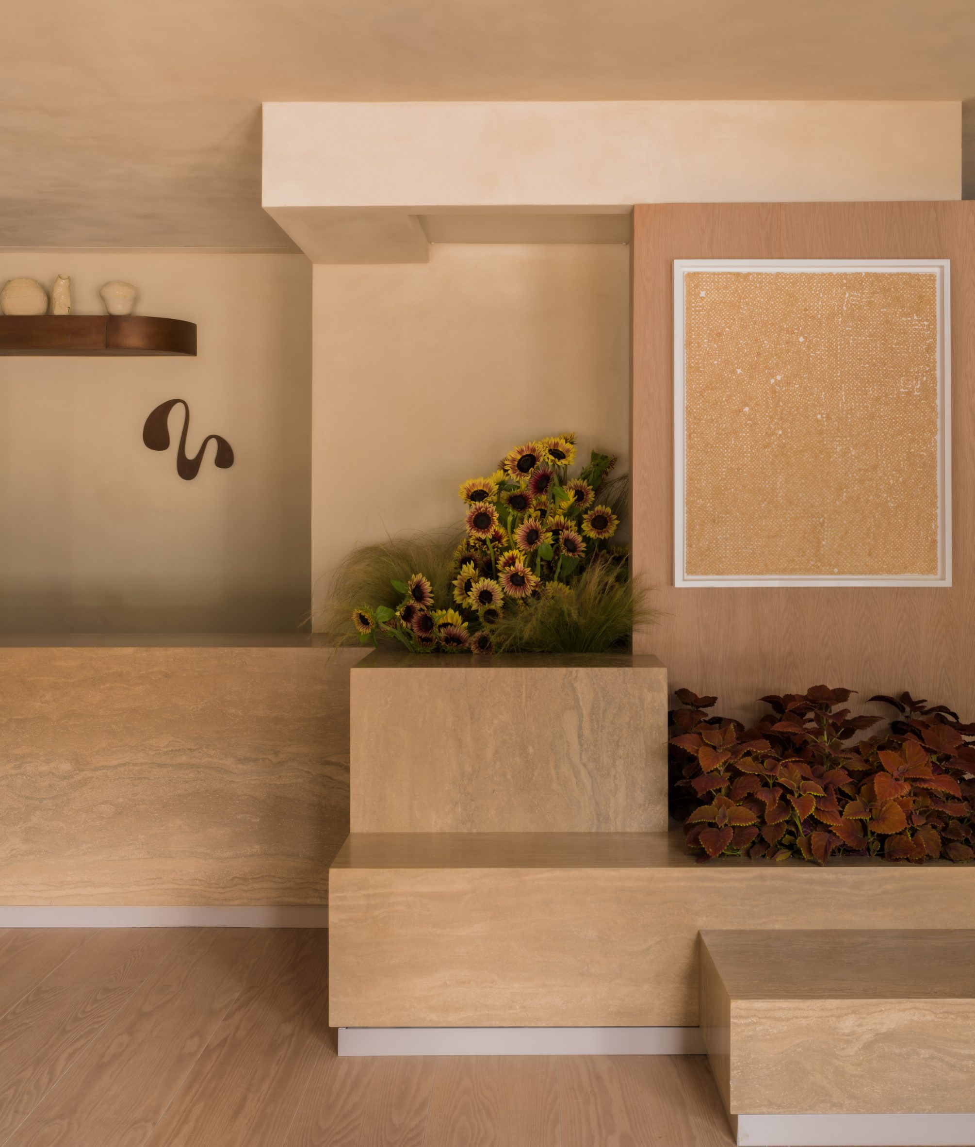 Stepped stone displays with floral planters, and an artwork on the wall